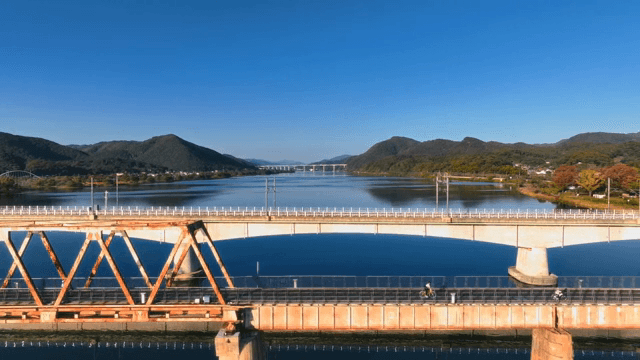 경치 좋은 호수 위의 다리에서 자전거 타는 사람들