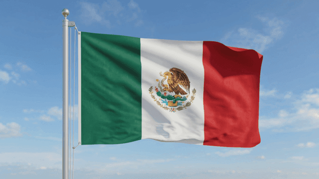Mexican flag waving against clear sky.