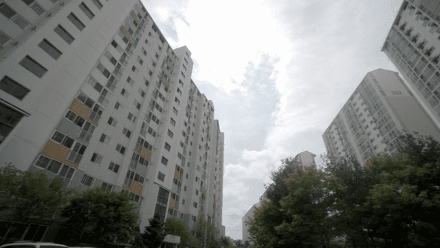 Tall apartment complex under cloudy sky