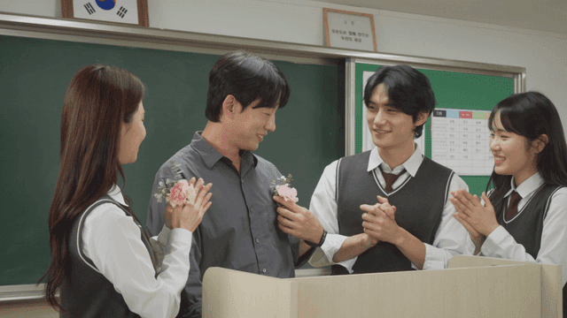 교실에서 꽃을 선물하며 스승의 날을 축하하는 학생들