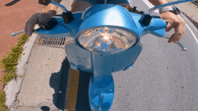 맑은 날 파란 스쿠터를 타는 사람