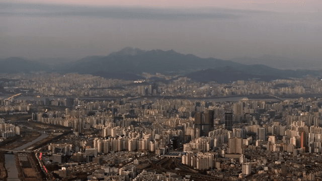 City at dusk with airplanes visible in the distance