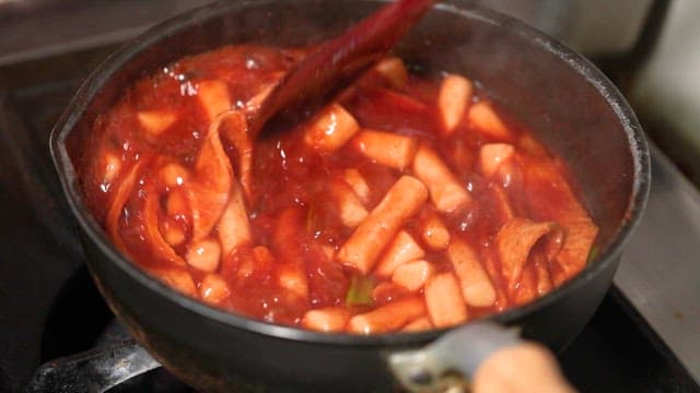 Cooking spicy Korean tteokbokki in pan