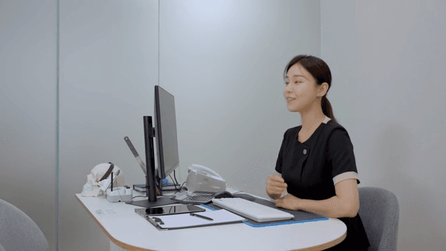 책상 앞에 앉아 환자를 맞이하는 상담실장