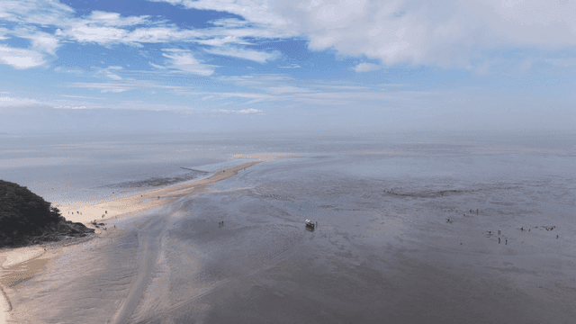 Quiet low-tide beach with island visible in distance