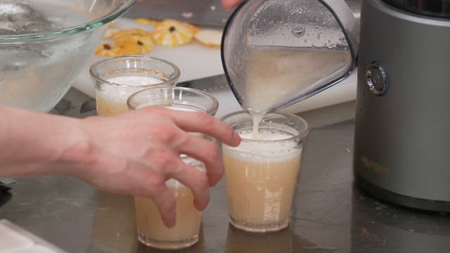 Pouring Fresh Korean Melon Juice into Glasses on a Kitchen Counter