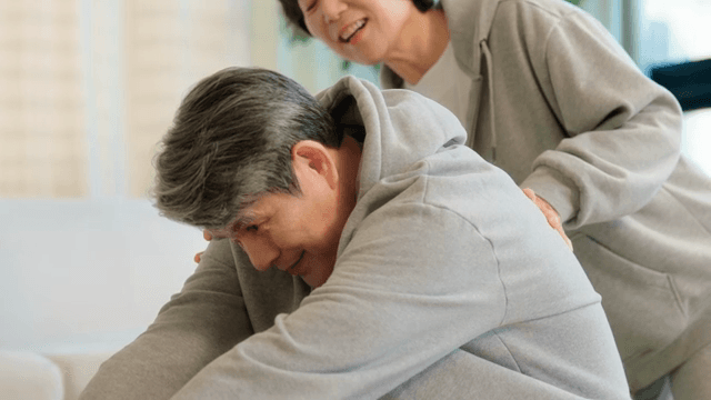 실내에서 스트레칭을 하는 노부부