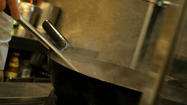 Chef stirring a steaming pot in the kitchen