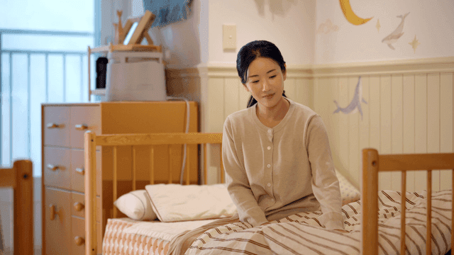 Middle-aged woman sitting in her child's room making bed
