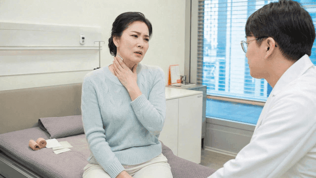 Woman wearing neck patch is consulting with doctor at hospital.