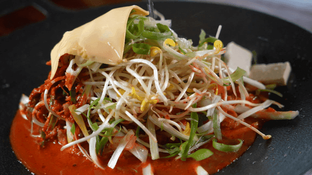 치즈와 콩나물이 올라간 부대찌개에 부어지는 육수