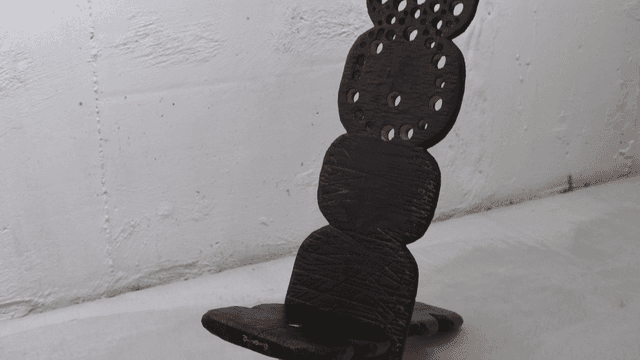 콘크리트 위에 독특한 디자인의 나무 조각상