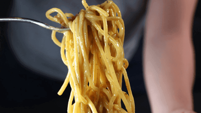Creamy pasta lifted with fork