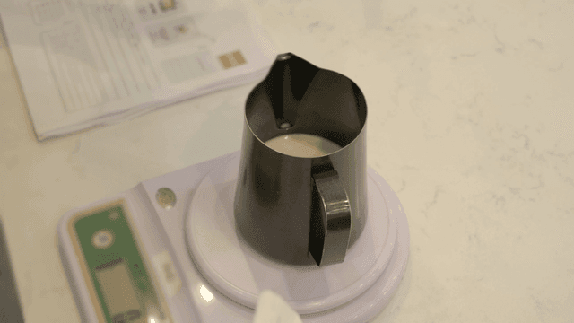 Milk in a black pitcher on a scale