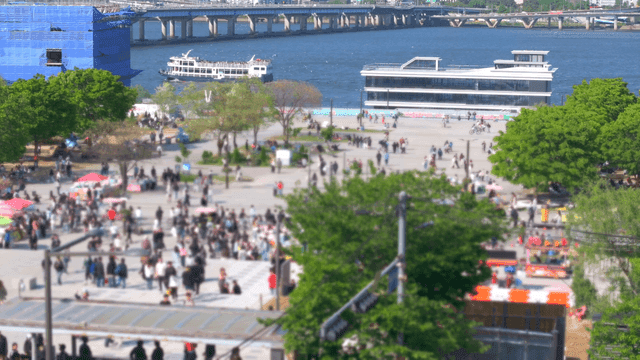 A bustling riverside park with people