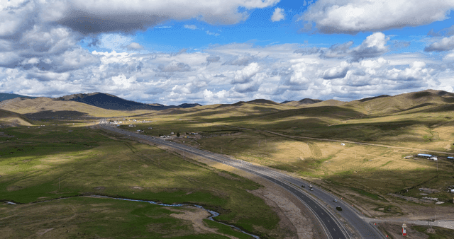 A winding road through vast green hills