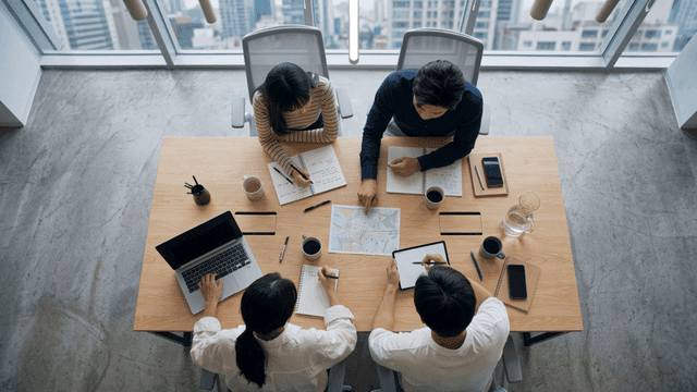Office meeting discussing while looking at map