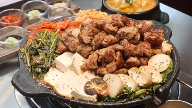 아늑한 식당의 불판에서 구운 신선한 고기와 채소들