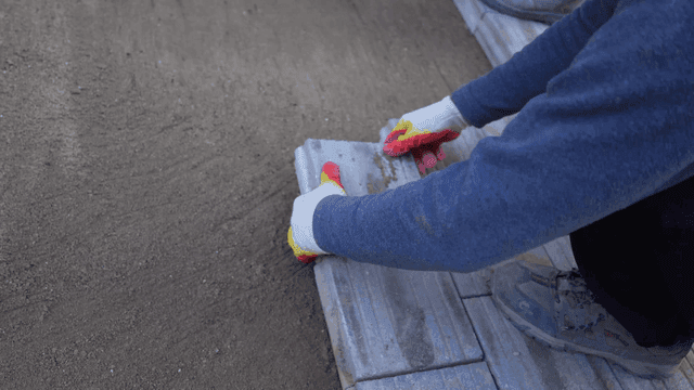Workers laying paving blocks on floor