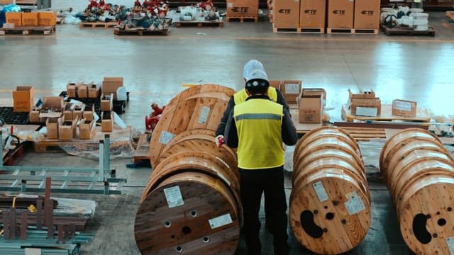 공장의 창고에서 목재 상품을 점검하는 작업자들