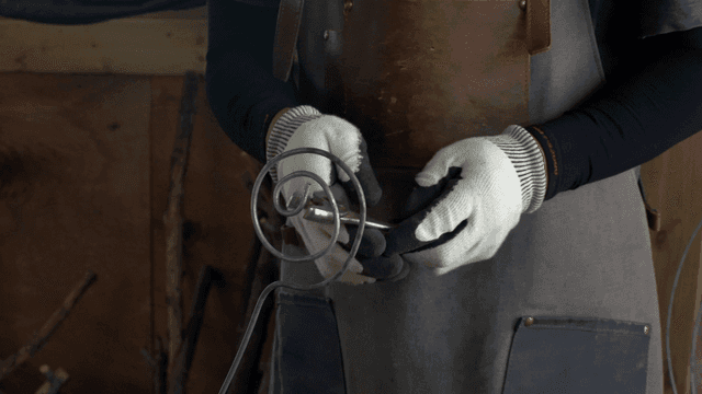 도구로 금속을 다듬는 사람