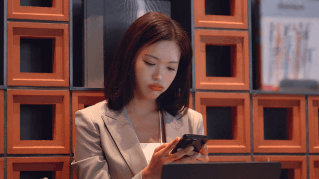 Female office worker checking her phone and sighing at cafe