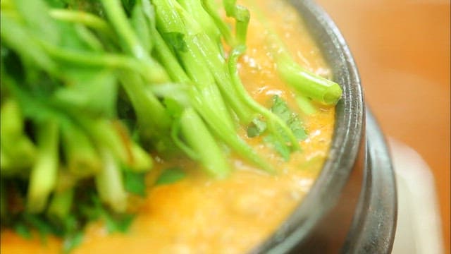 Boiling duck soup topped with water parsley