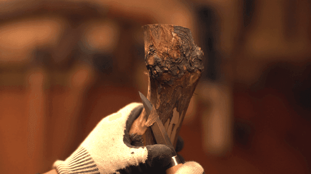 실내에서 칼로 나무를 조각하는 손