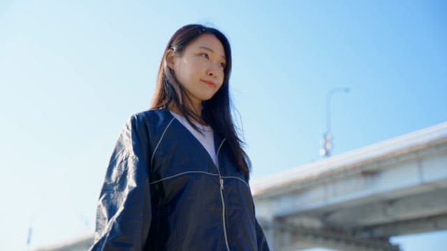 Woman stretching under a bridge