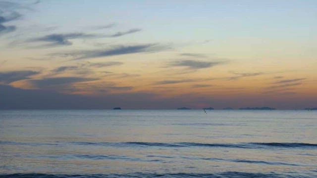 멀리 섬이 보이는 평화로운 일몰의 해변 풍경