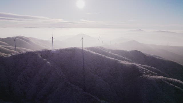 Wind Generators on Misty and Snowy Mountain in the Morning