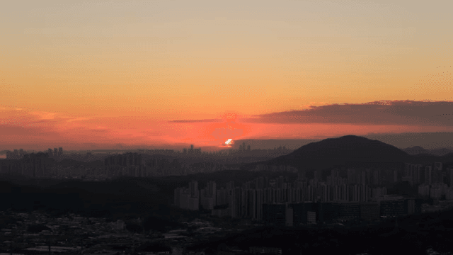 산과 도시 스카이라인 위의 일몰