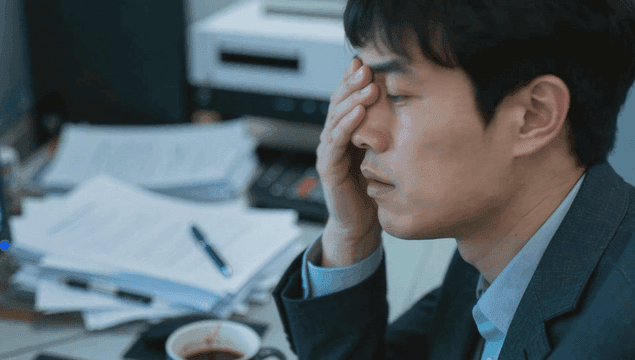 사무실 책상에서 눈치를 보며 일하는 직장인 남자