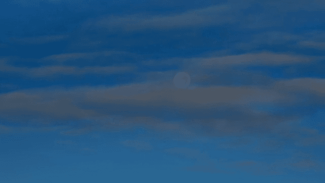 Moon visible through scattered clouds