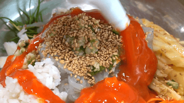 Spicy sauce poured over ice fish rice bowl