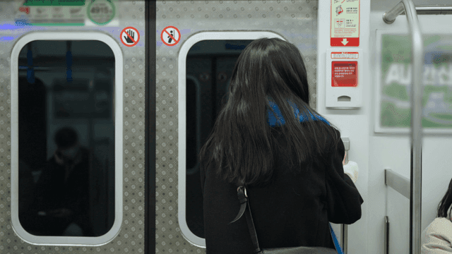 Back view of a woman standing in the subway