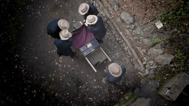 모자를 쓴 남자들이 나무 구조물을 준비하는 모습