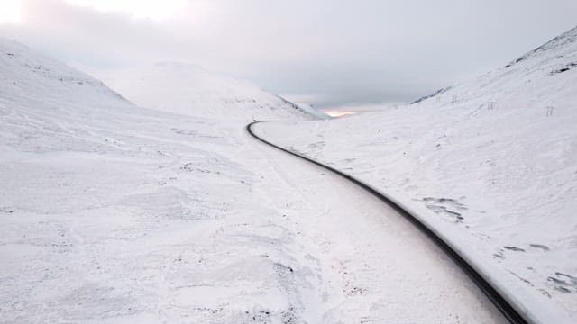 Winding road through snowy mountains