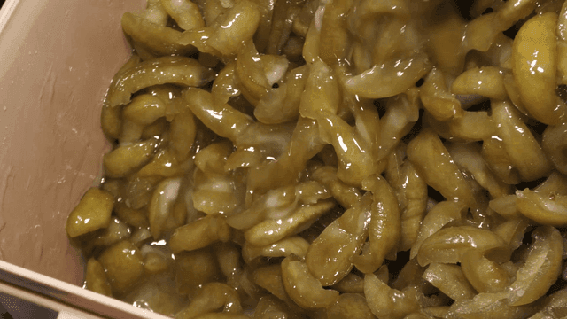 Plum syrup pickled with gloved hands