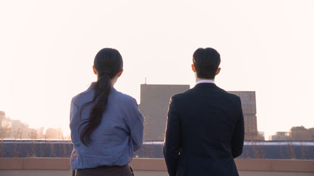 Two people discussing on a rooftop