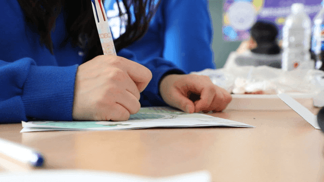 Student writing notes in a classroom