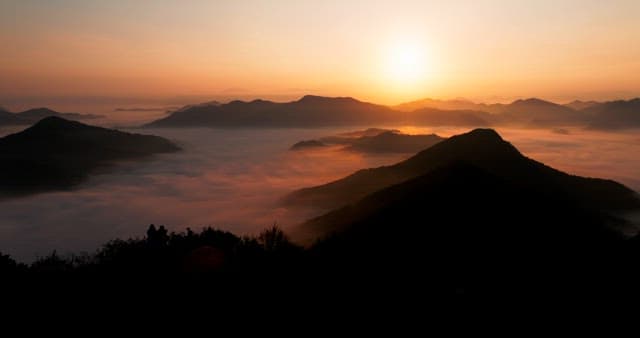 Sky Colored by Sunrise over Foggy Mountains