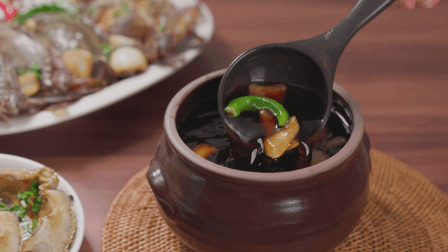Jar filled with soy sauce marinade for crab