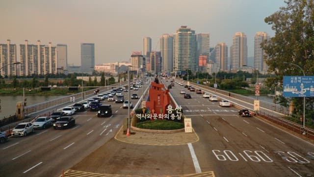 Pedestrians and cars passing over the Hangang Bridge connecting the city at sunset