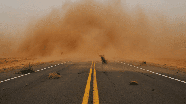 Desert road engulfed in sandstorm.