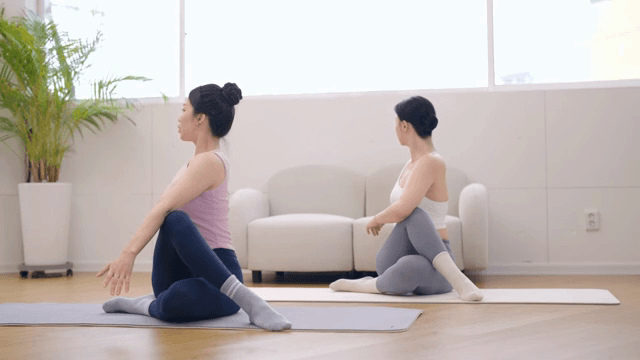 실내에서 요가 강사가 수강생을 지도하는 모습