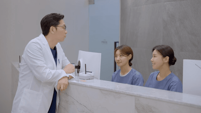 병원 접수 데스크에서 간호사들과 대화하는 의사