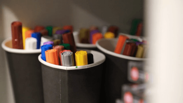 선반 위 검은 컵에 담긴 색색의 마커