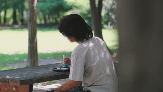 Person enjoying a meal at a park table