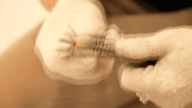 장갑을 낀 손이 커터칼을 사용하는 모습